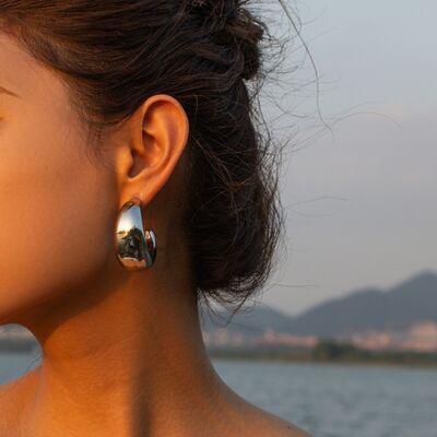 a close up of a person wearing a pair of earrings