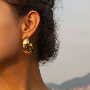 a close up of a person wearing a pair of earrings