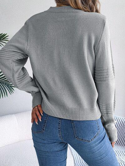 a woman wearing a grey sweater and jeans