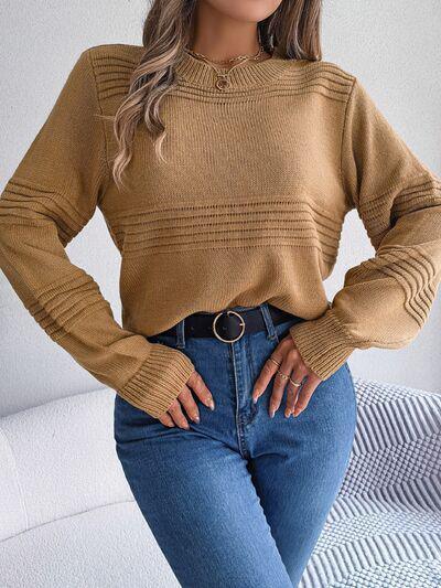 a woman sitting on a couch wearing a tan sweater
