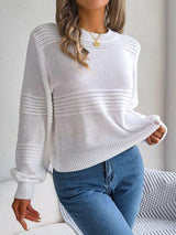 a woman wearing a white sweater and jeans