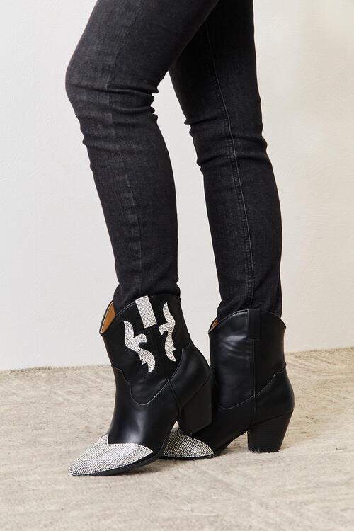 a pair of black boots with silver accents