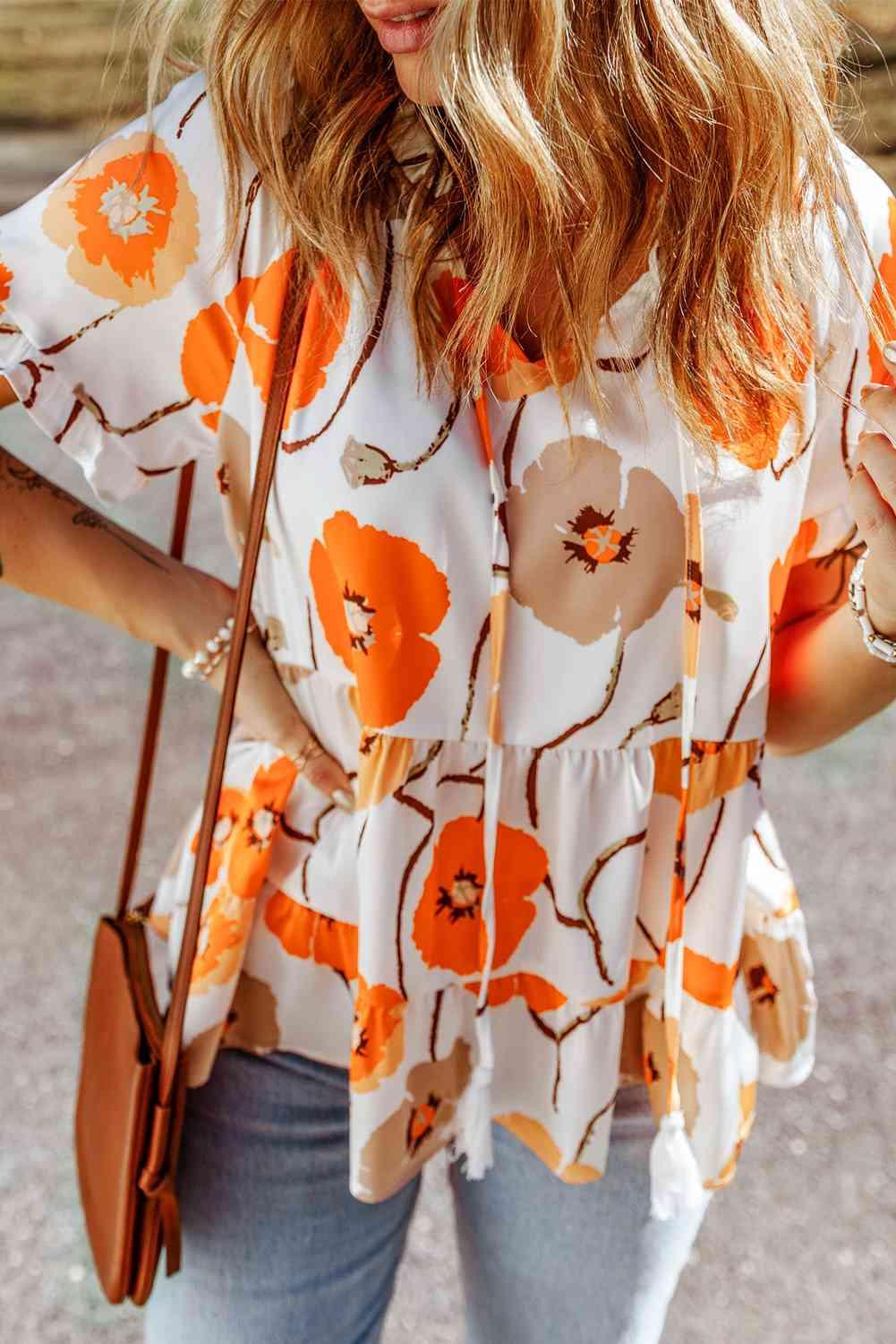 a woman wearing a floral blouse and jeans