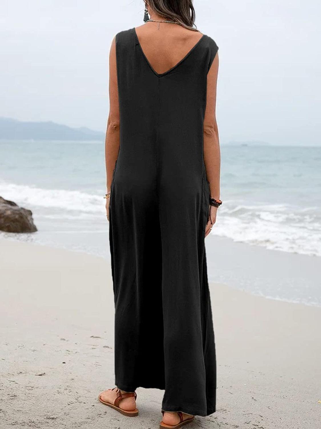 a woman standing on a beach looking out at the ocean