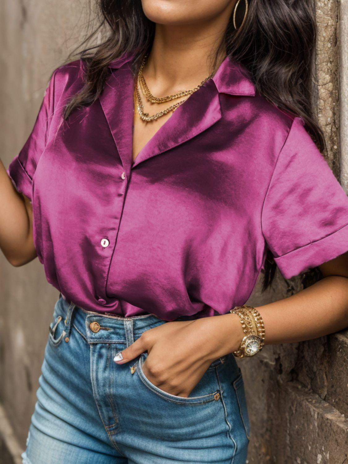 a woman in a pink shirt and jeans leaning against a wall