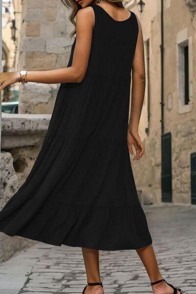 a woman in a black dress standing on a cobblestone street
