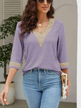 a woman wearing a purple top and jeans