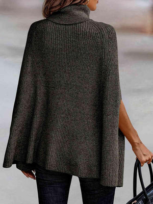 a woman in a gray sweater carrying a black bag