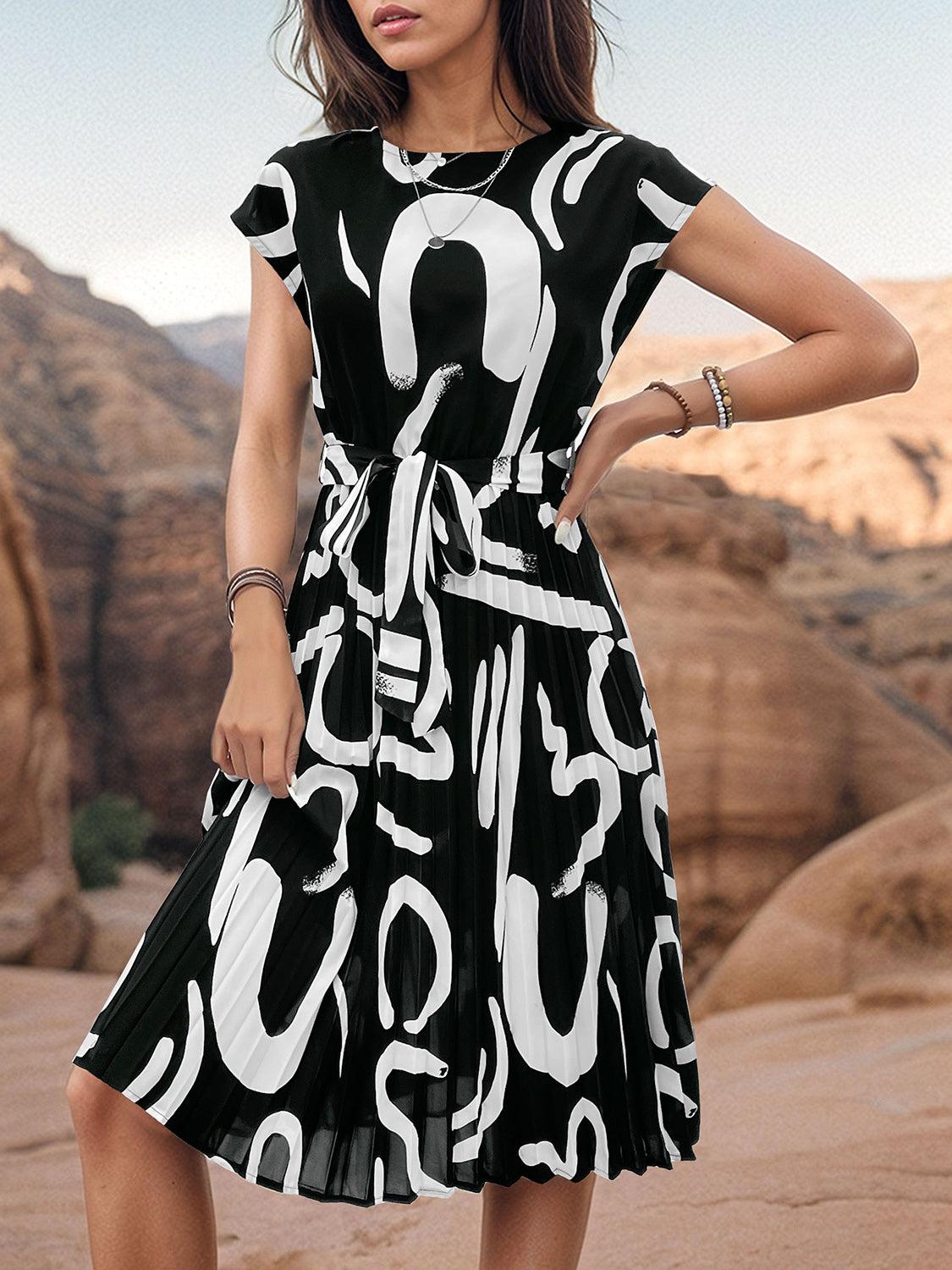 a woman in a black and white dress posing for a picture