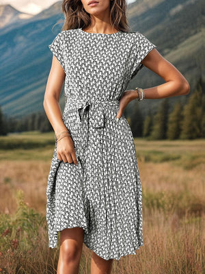 a woman standing in a field with mountains in the background