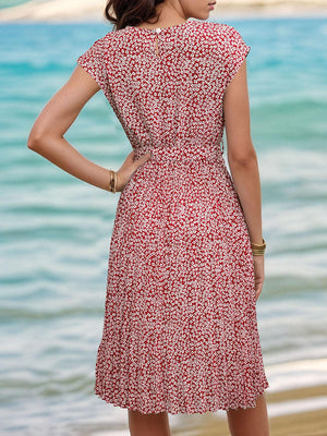 a woman in a red and white dress standing on a beach