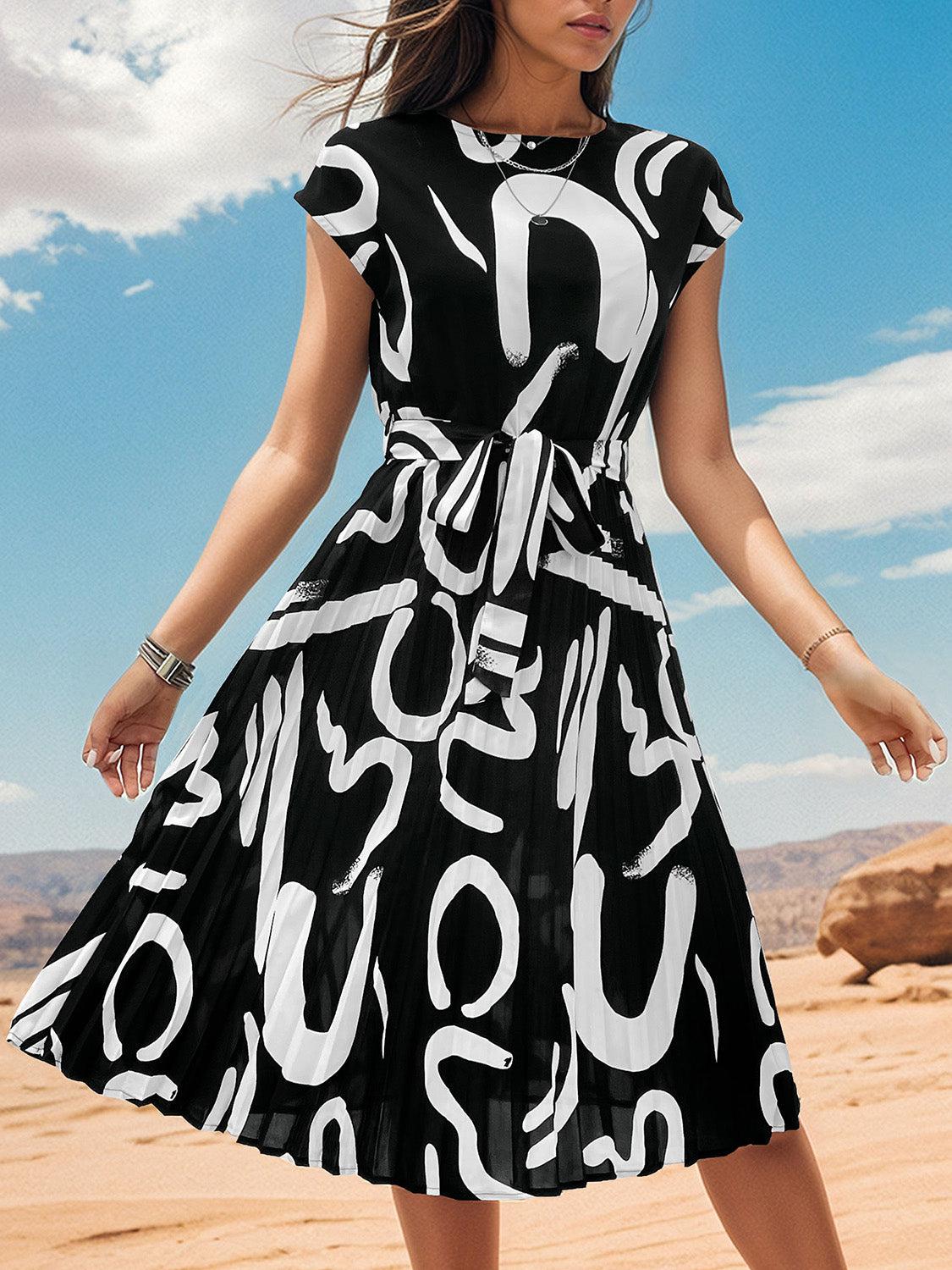 a woman in a black and white dress standing in the desert