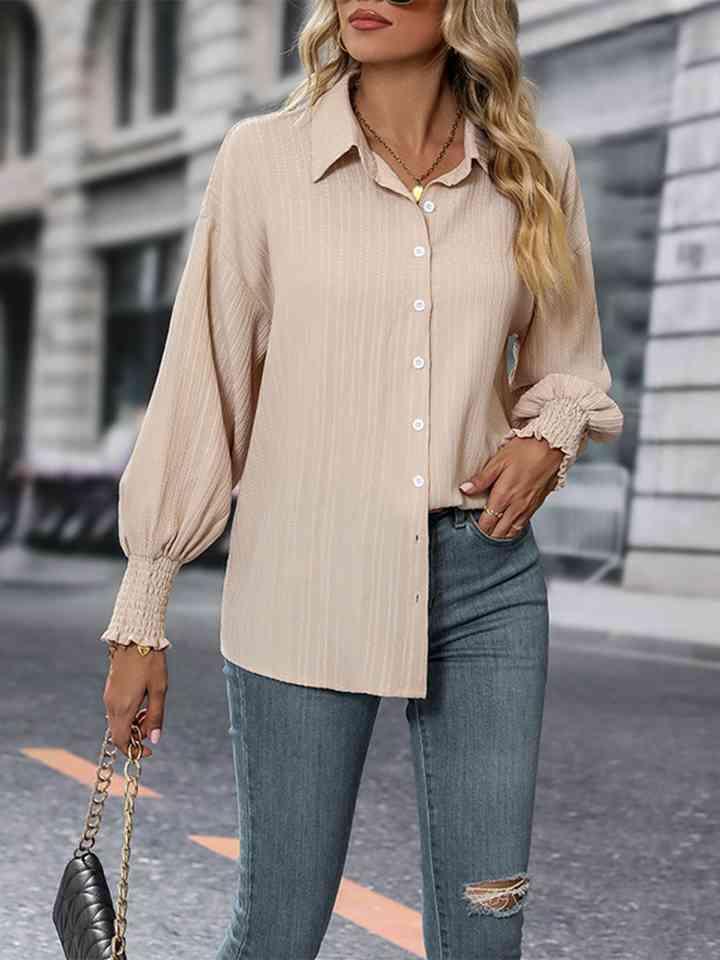 a woman wearing a beige shirt and ripped jeans