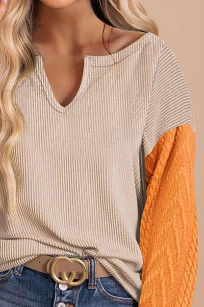 a woman with blonde hair wearing a tan sweater and jeans