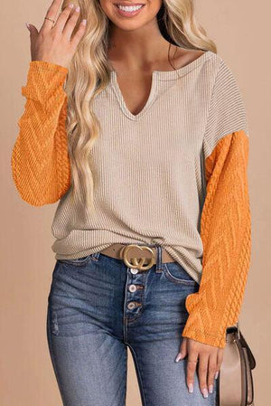 a woman wearing an orange sweater and jeans