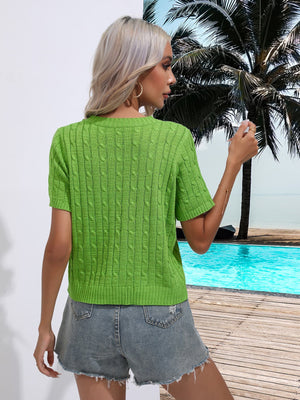 a woman standing next to a pool wearing a green sweater