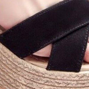 a close up of a person's shoes with a black ribbon