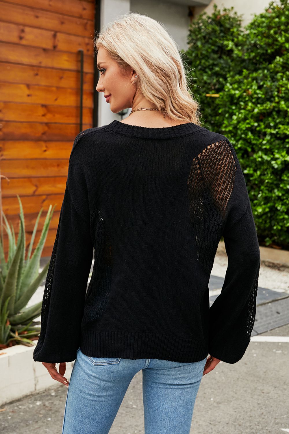 a woman wearing a black sweater and jeans