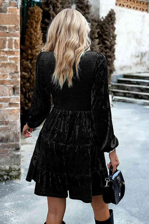 a woman in a black dress is walking down the street