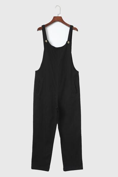 a child's black overalls hanging on a hanger