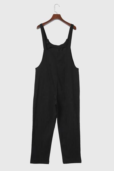 a black jumpsuit hanging on a wooden hanger