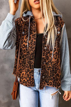 a woman wearing a leopard print jacket and jeans