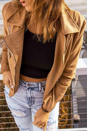 a woman wearing a brown jacket and ripped jeans