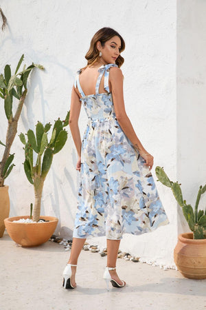 a woman in a dress standing next to a cactus