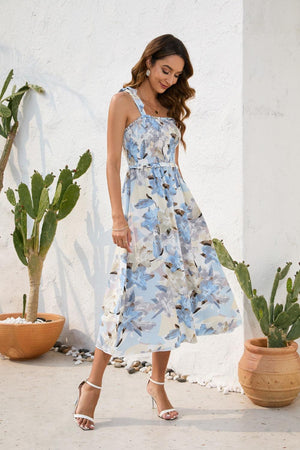 a woman in a blue and white dress standing next to a cactus