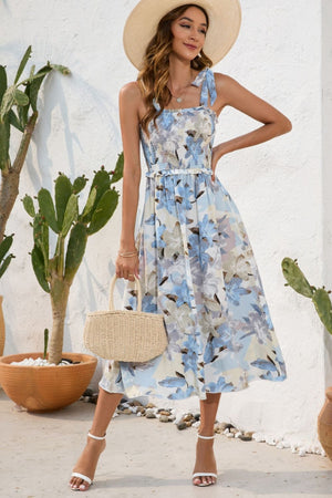 a woman wearing a blue floral dress and a straw hat