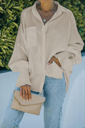 a woman wearing a beige shirt and jeans