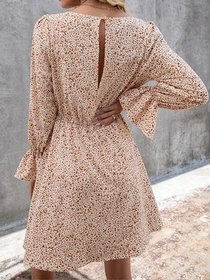 a woman wearing a brown floral print dress