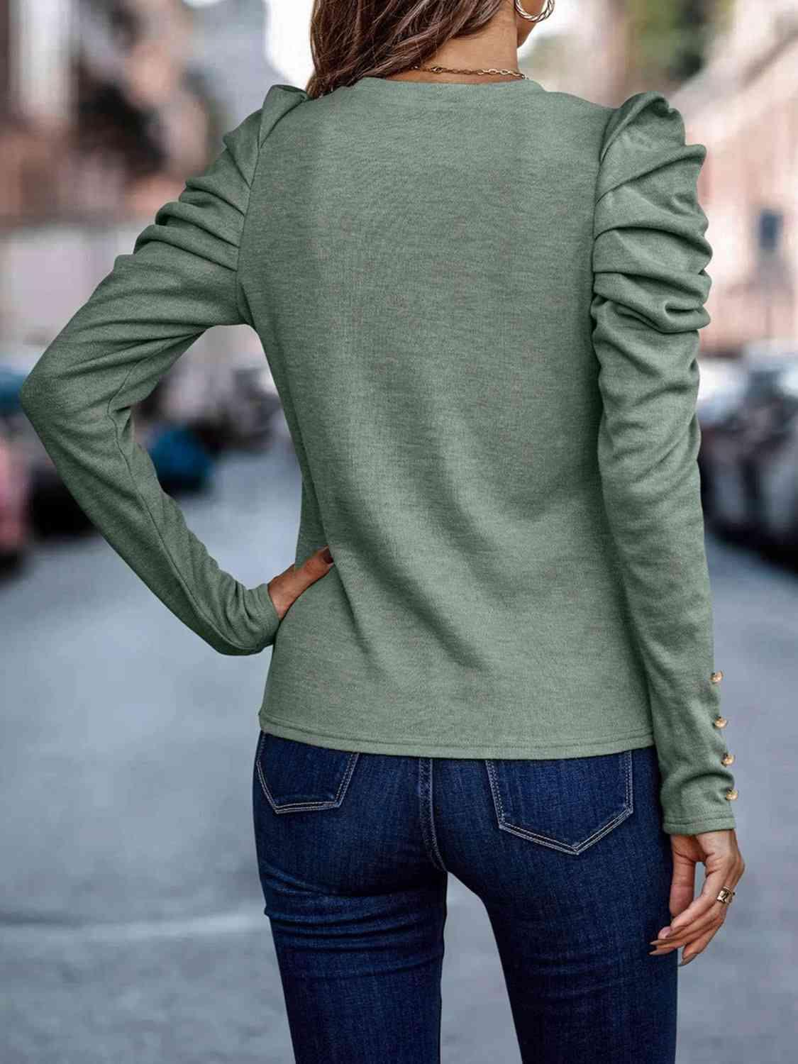 a woman wearing a green sweater and jeans