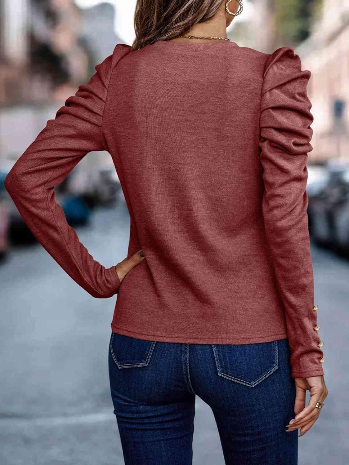 a woman wearing a red sweater and jeans