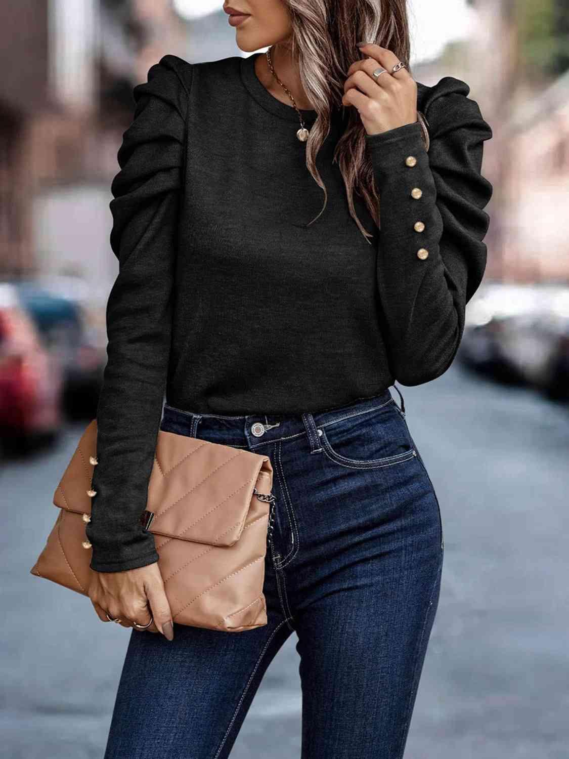 a woman wearing a black sweater and jeans