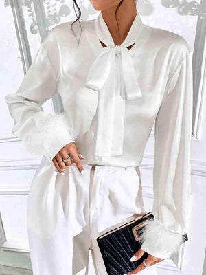 a woman wearing a white blouse and white pants