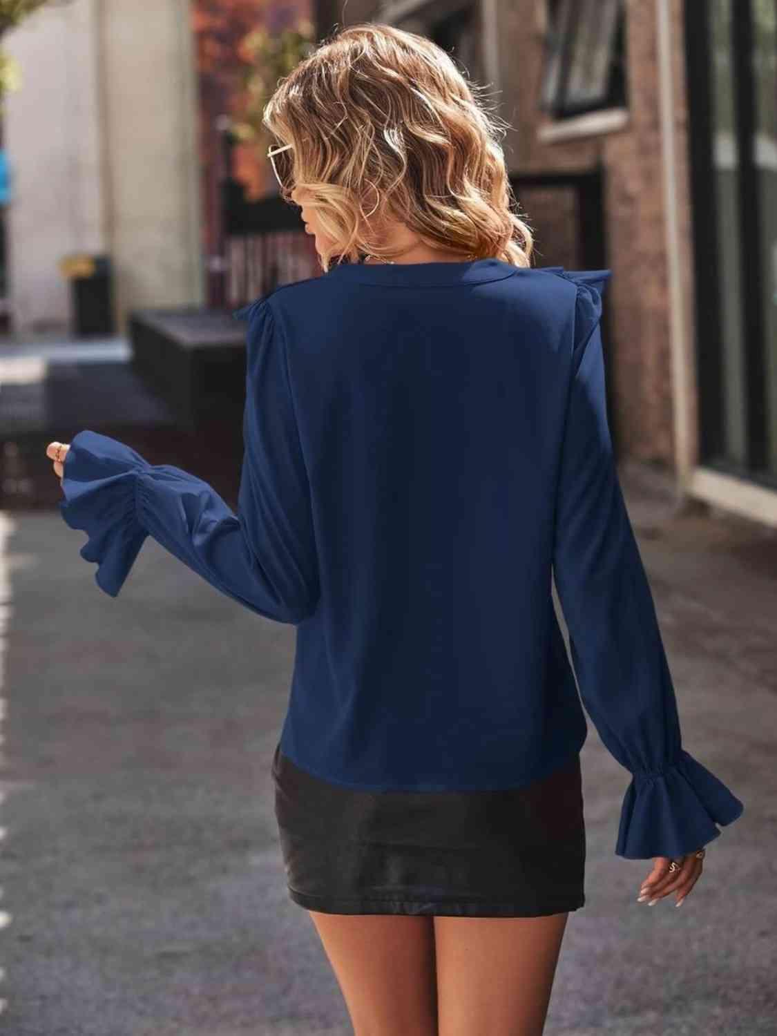 a woman walking down a street wearing a blue top