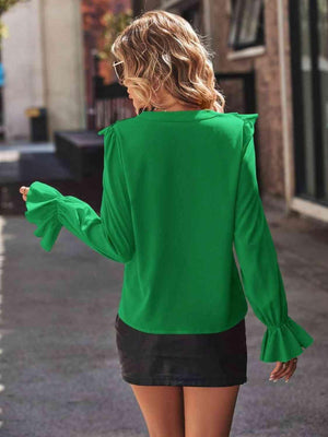 a woman walking down a street wearing a green top