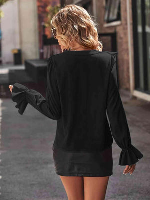 a woman walking down a street wearing a black dress