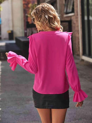 a woman walking down a street wearing a pink top