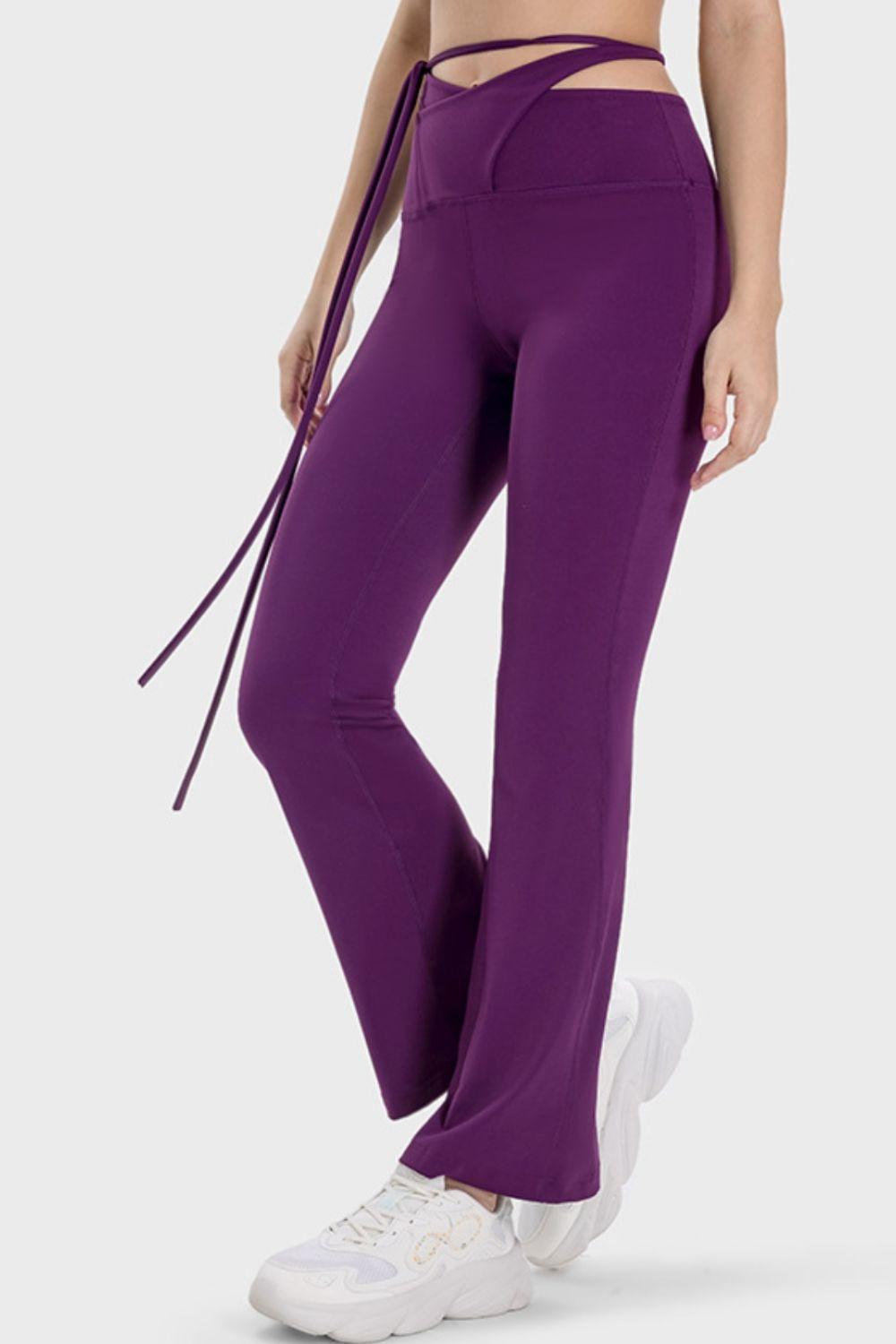 a woman wearing purple pants and a bra top