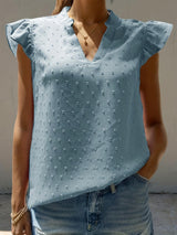 a woman wearing a blue blouse and jeans