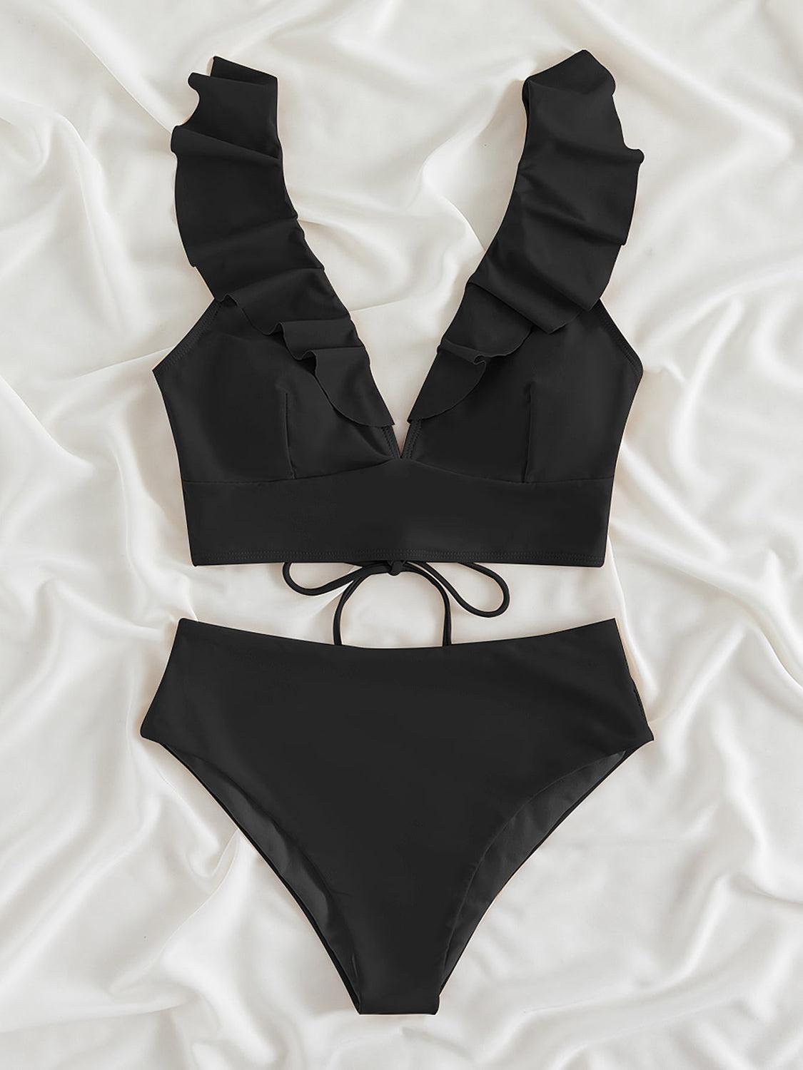a black bikini top and bottom on a white sheet