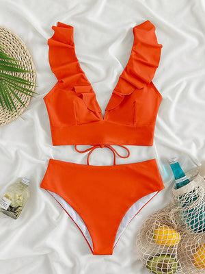 a woman's swimsuit and accessories on a bed