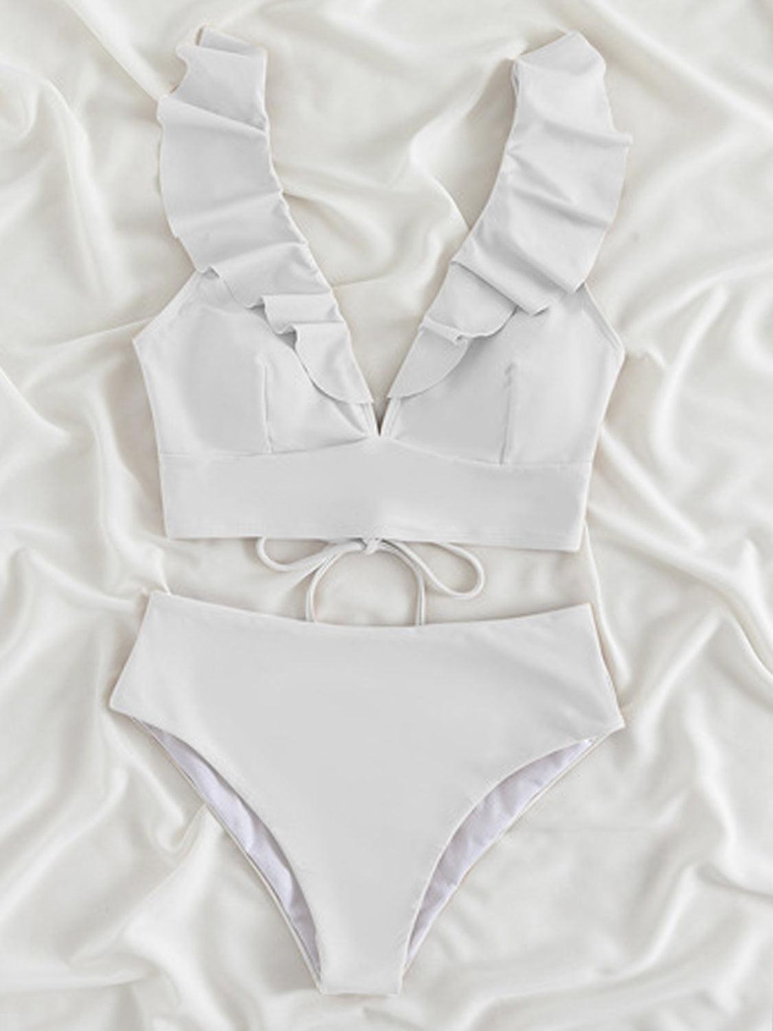 a white bikini top and bottom on a bed