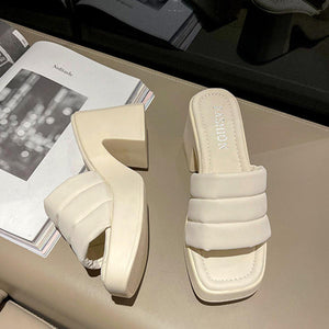 a pair of white sandals sitting on top of a table