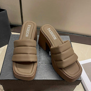 a pair of brown sandals sitting on top of a box