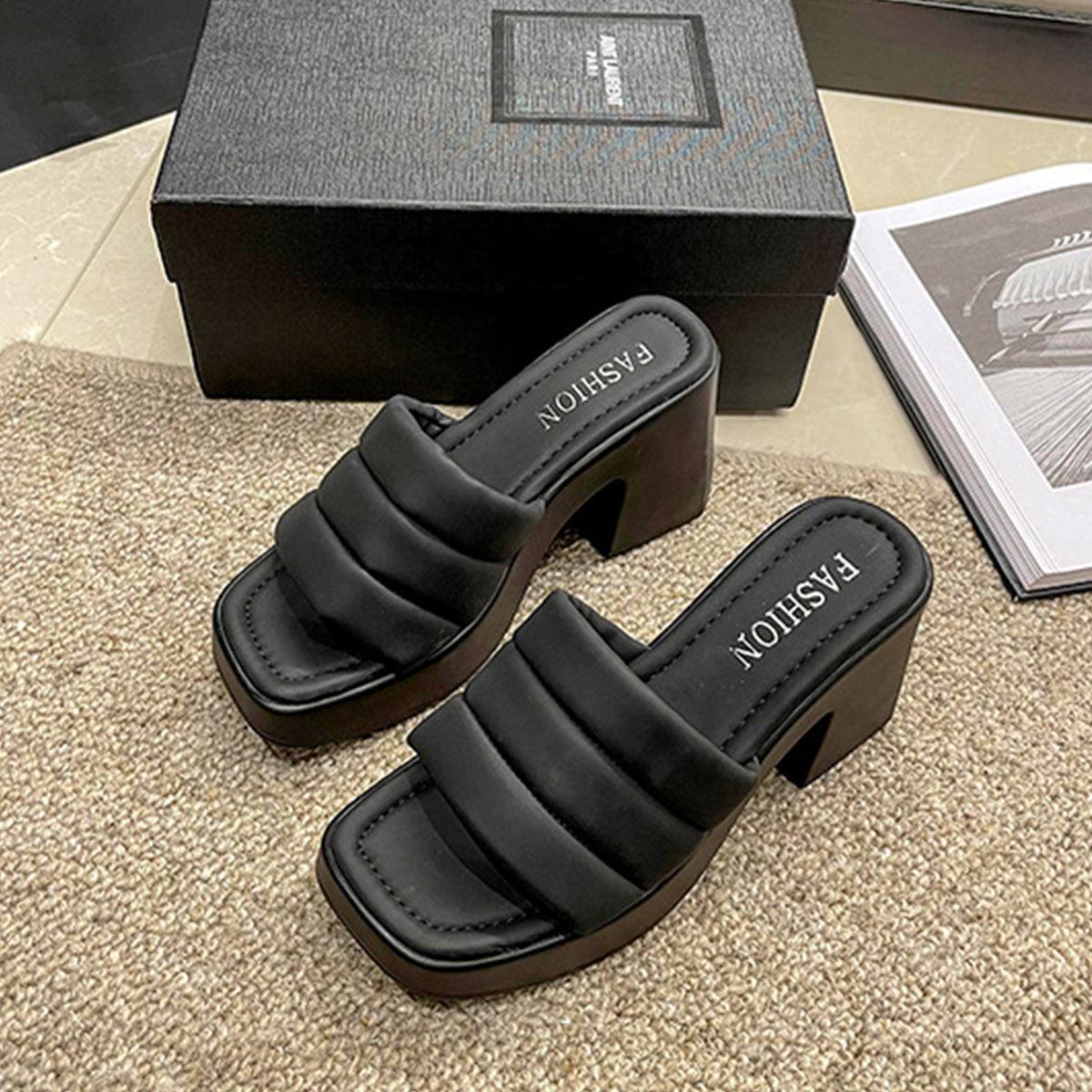 a pair of black sandals sitting on top of a table