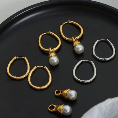 five pairs of earrings on a black tray