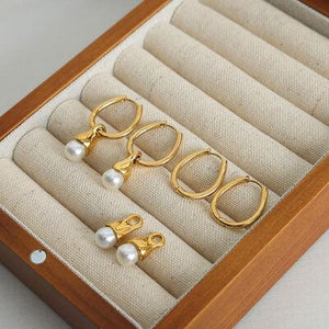 three pairs of earrings in a wooden box